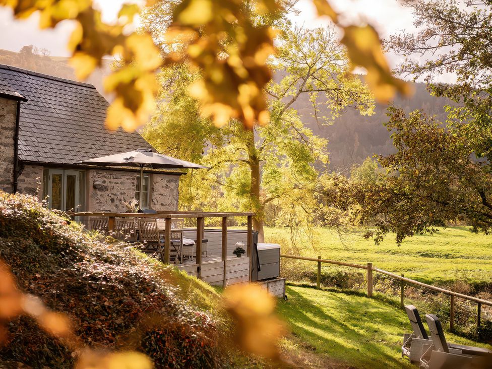 A house with a deck and furniture at Flyfishers Cottage in Llandrillo