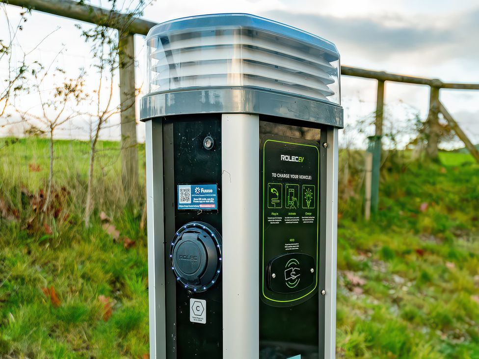 An electric vehicle charging station in an outdoor area at Flyfishers Cottage in Llandrillo