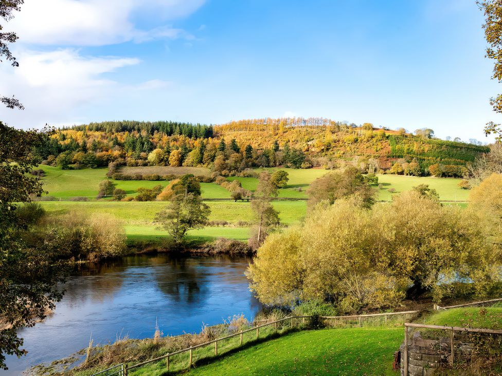 A scenic view of hills and a river at Flyfishers Cottage in Llandrillo