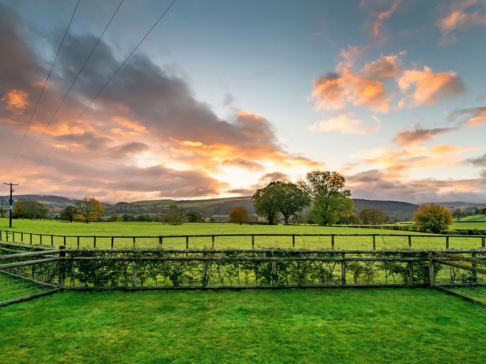 A landscape view with trees and mountains at Flyfishers Cottage in Llandrillo