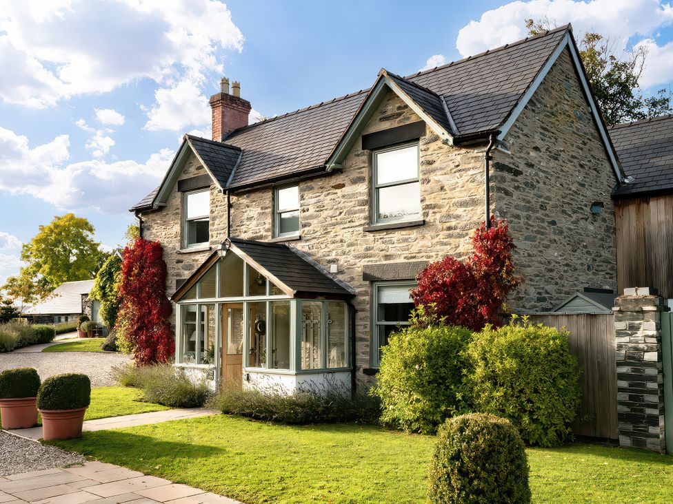 A house with stone exterior and garden at Cilan Farmhouse in Llandrillo