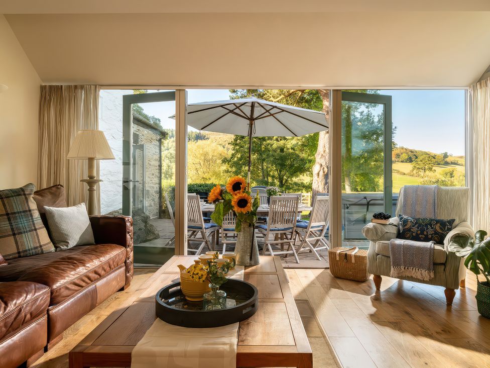A living room with a sofa and coffee table at Cilan Farmhouse Llandrillo