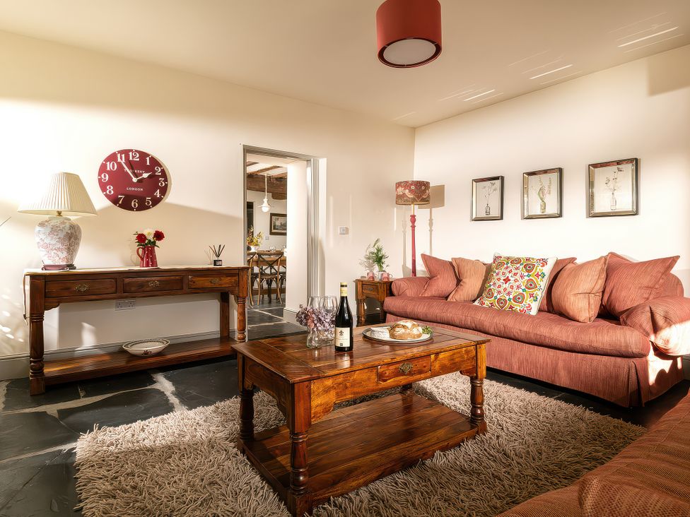 A living room with a sofa and coffee table at Cilan Farmhouse in Llandrillo