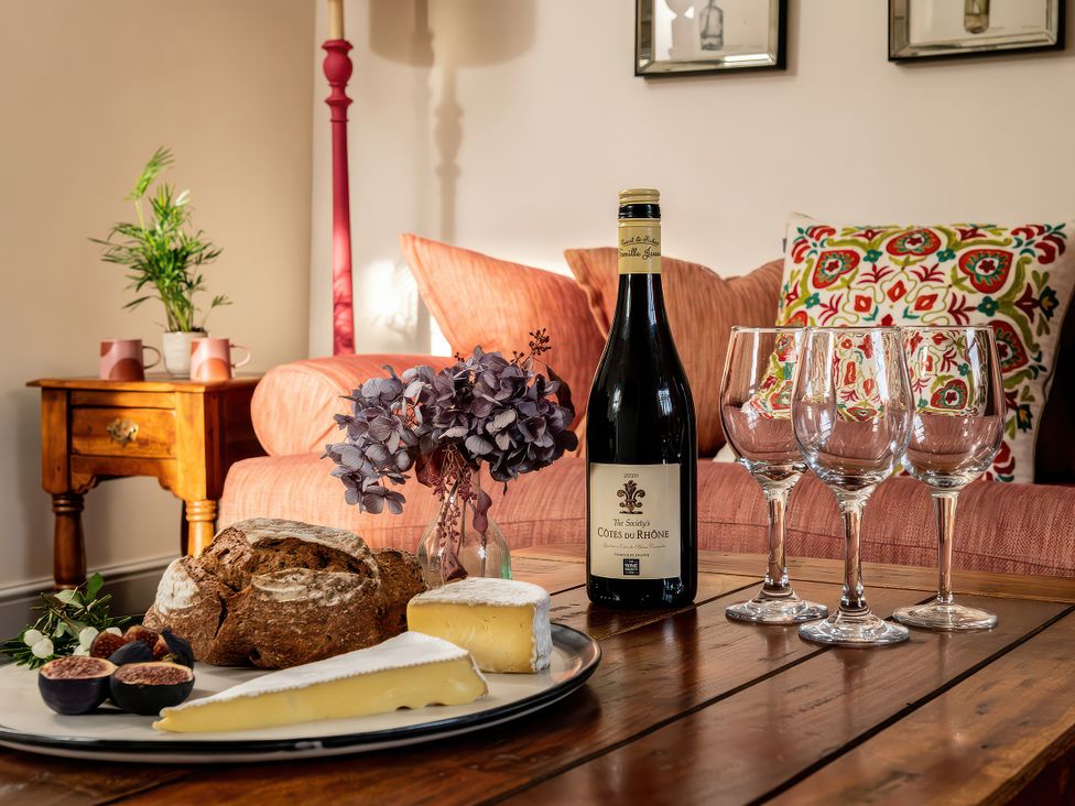 A living room with a coffee table and wine on it at Cilan Farmhouse in Llandrillo