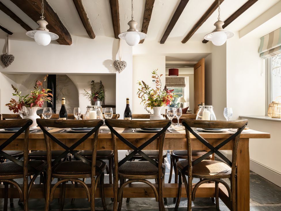 A dining room with a wooden table and chairs at Cilan Farmhouse in Llandrillo
