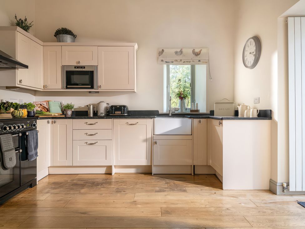 A kitchen with cabinets, sink, and appliances at Cilan Farmhouse in Llandrillo