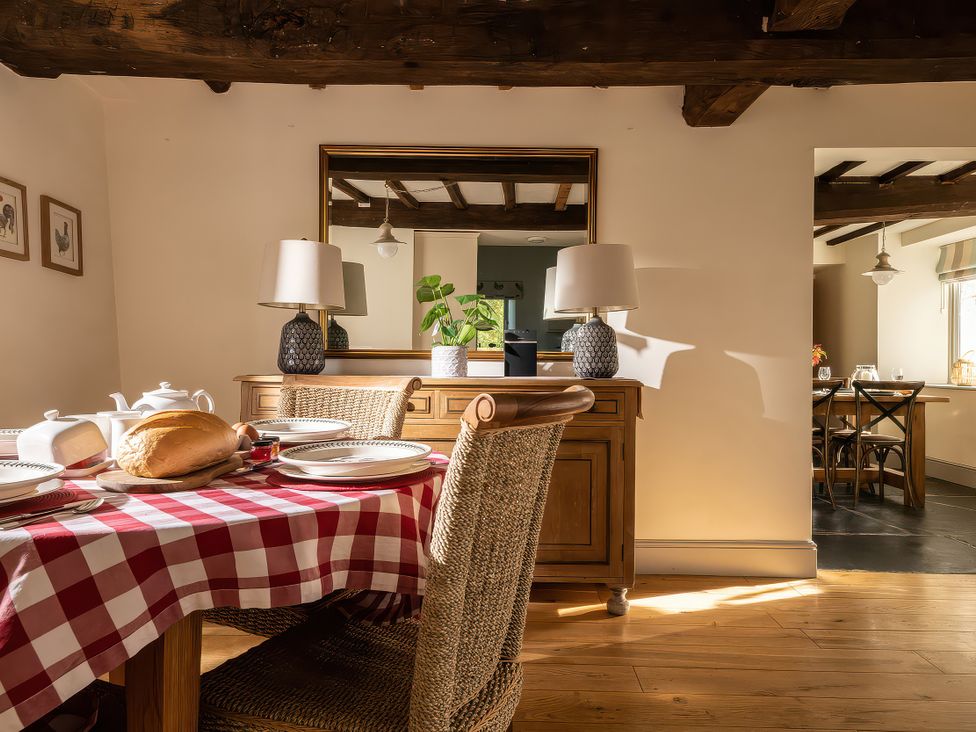 A dining room with a table set and a cabinet at Cilan Farmhouse in Llandrillo