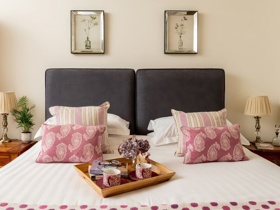 A bedroom with a bed and bedside lamps at Cilan Farmhouse in Llandrillo