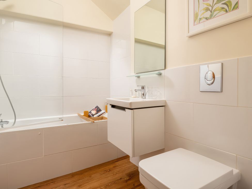A bathroom with a bathtub and sink at Cilan Farmhouse in Llandrillo