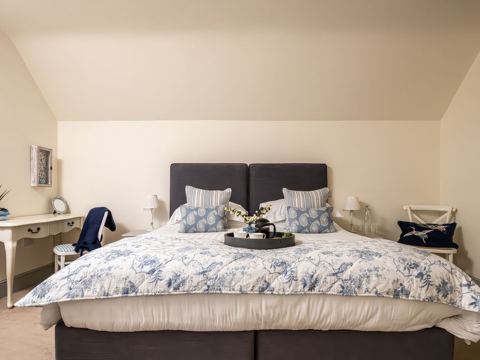 A bedroom with a bed and bedside table at Cilan Farmhouse in Llandrillo