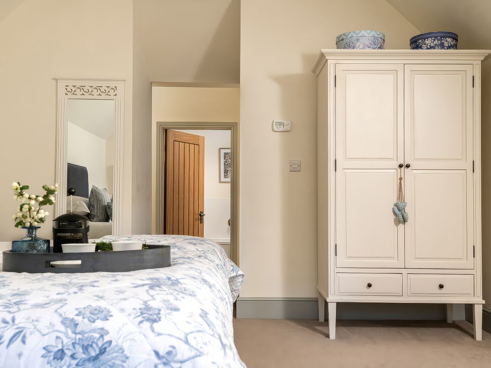 A bedroom with a bed and wardrobe at Cilan Farmhouse in Llandrillo