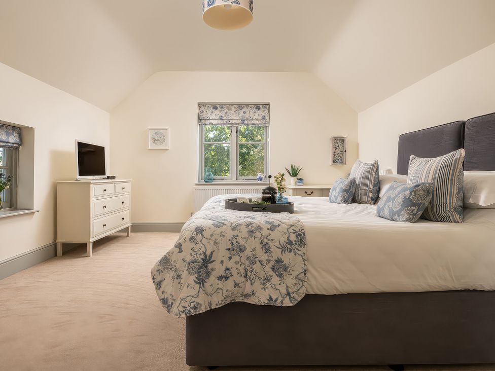 A bedroom with a bed and a television at Cilan Farmhouse in Llandrillo