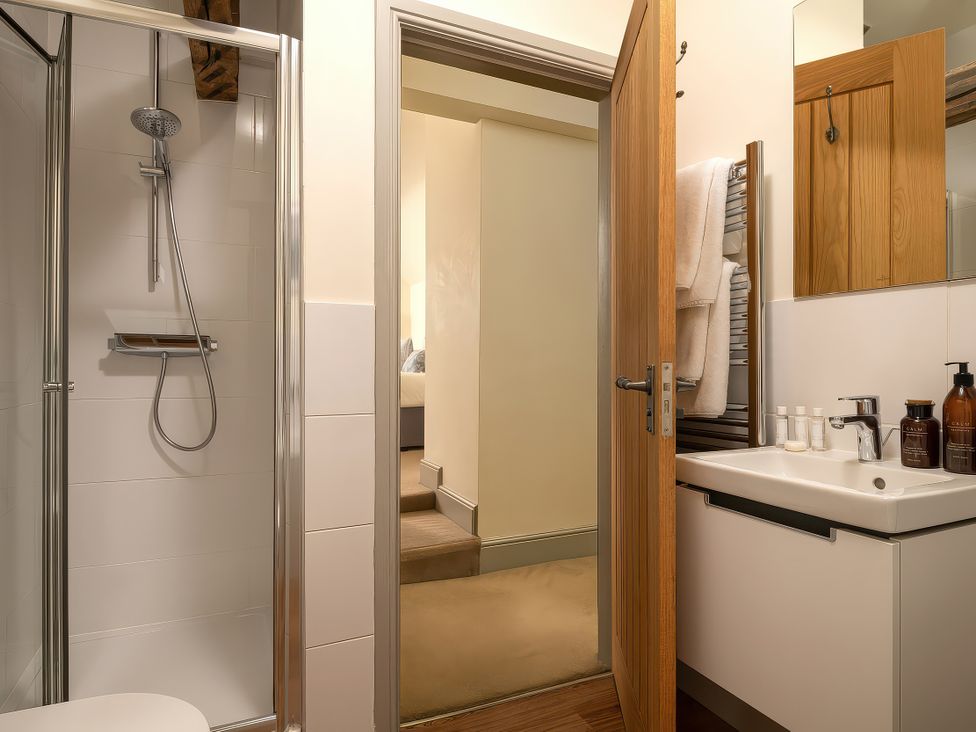 A bathroom with a shower and sink at Cilan Farmhouse in Llandrillo