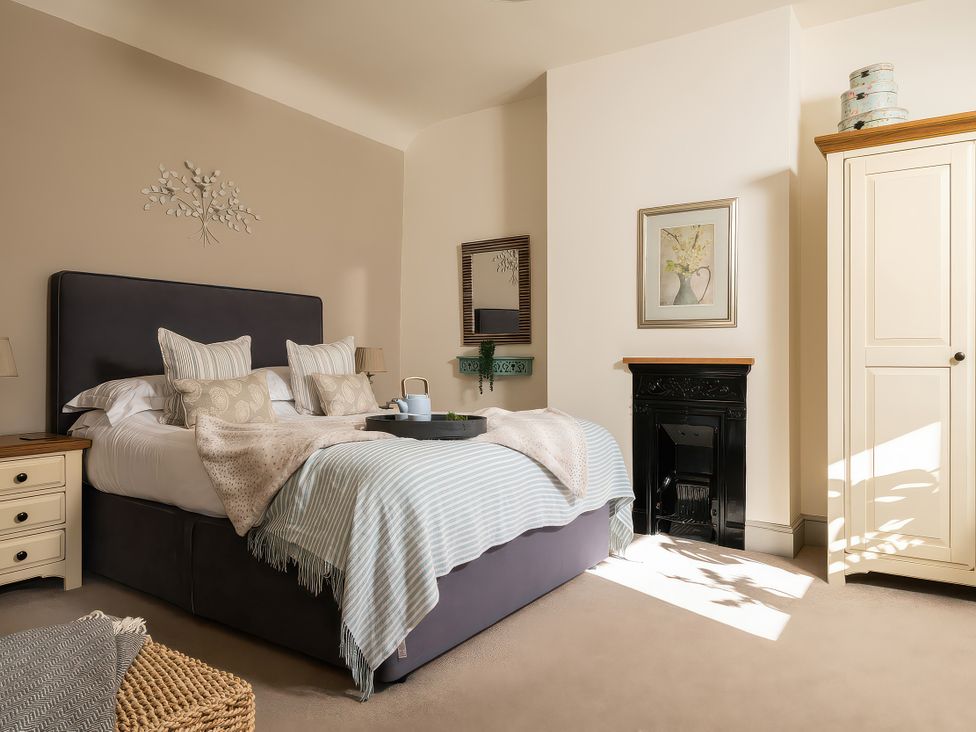 A bedroom with a bed and a wardrobe at Cilan Farmhouse in Llandrillo