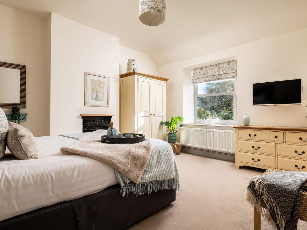 A bedroom with a bed and dresser at Cilan Farmhouse in Llandrillo