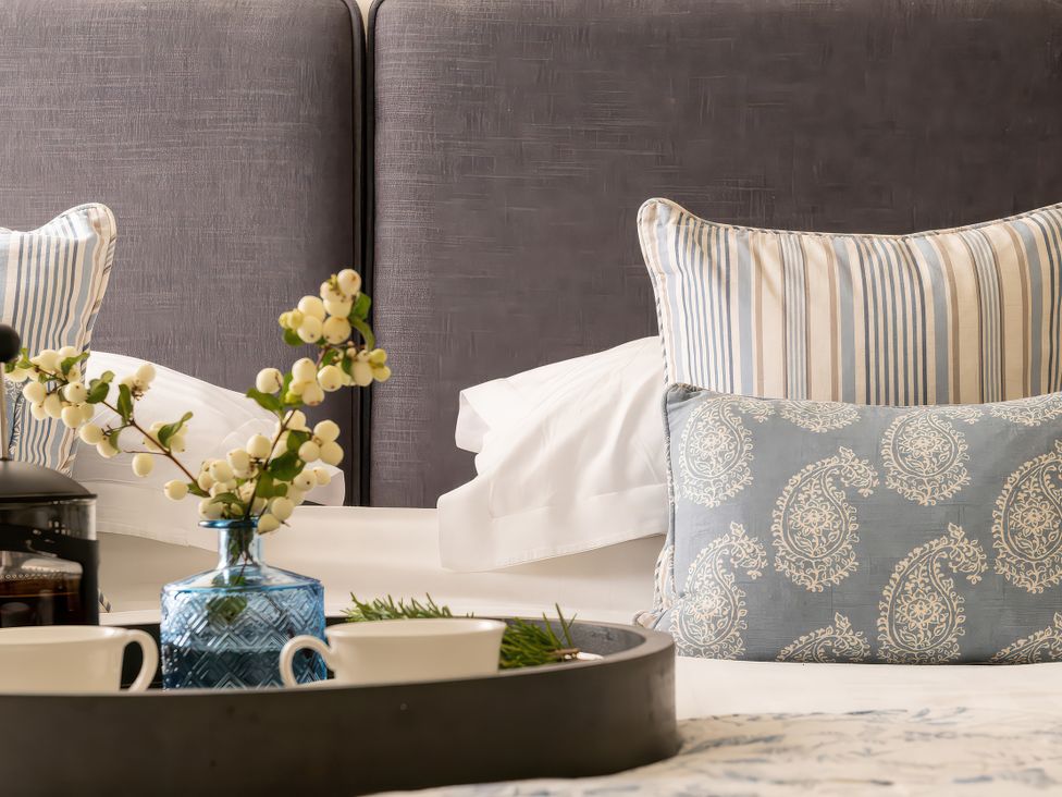 A bedroom with pillows and a tray with coffee at Cilan Farmhouse in Llandrillo