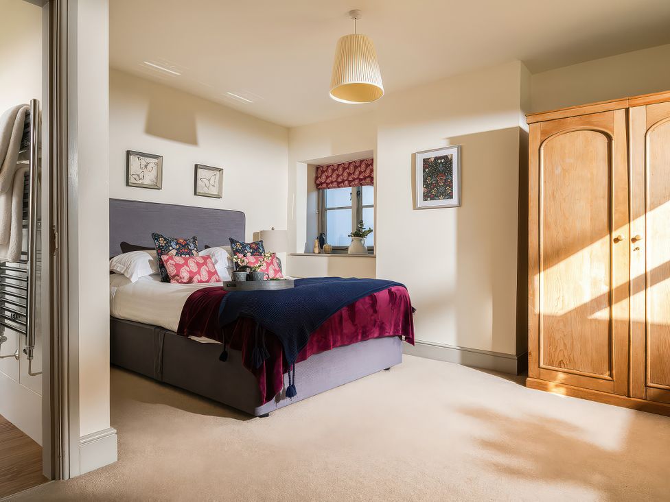 A bedroom with a bed and wardrobe at Cilan Farmhouse Llandrillo