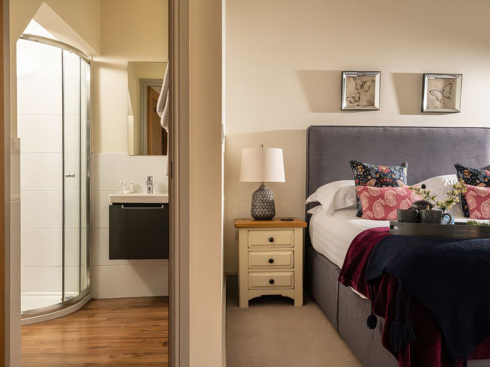 A bedroom with a bed and bathroom area at Cilan Farmhouse Llandrillo