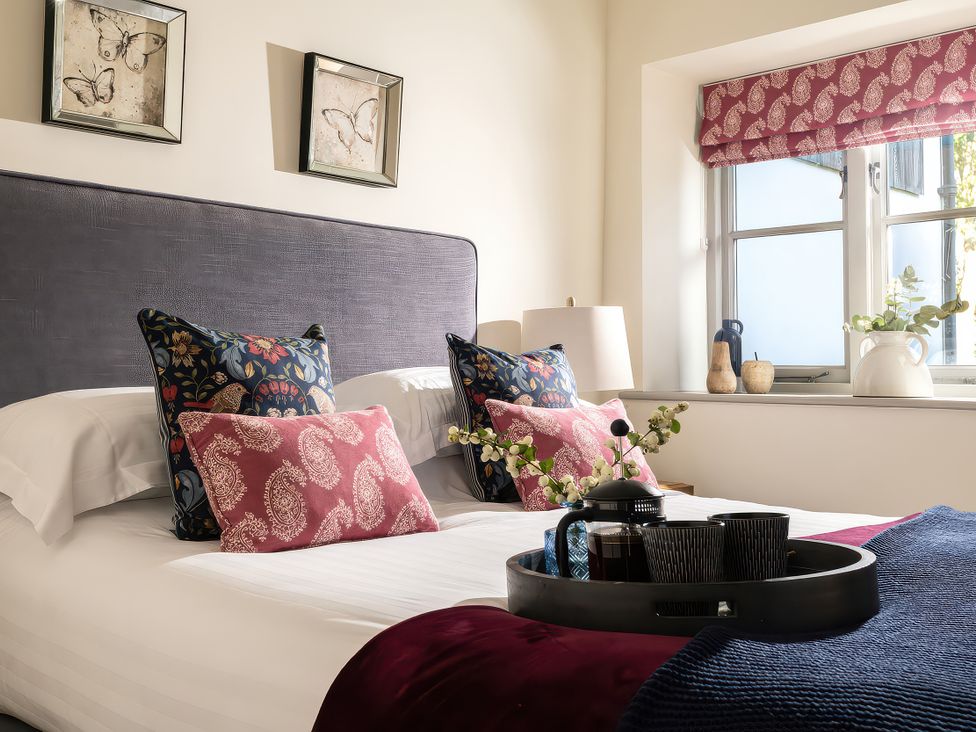 A bedroom with a bed and decorative pillows at Cilan Farmhouse in Llandrillo