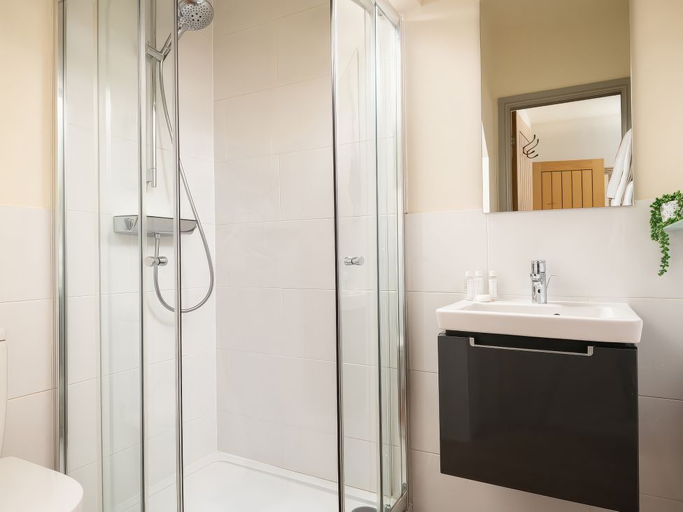 A bathroom with a shower and a sink at Cilan Farmhouse in Llandrillo