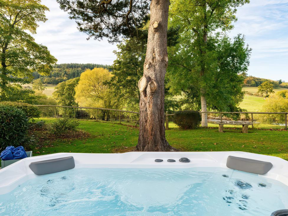 A hot tub placed in an outdoor area at Cilan Farmhouse in Llandrillo