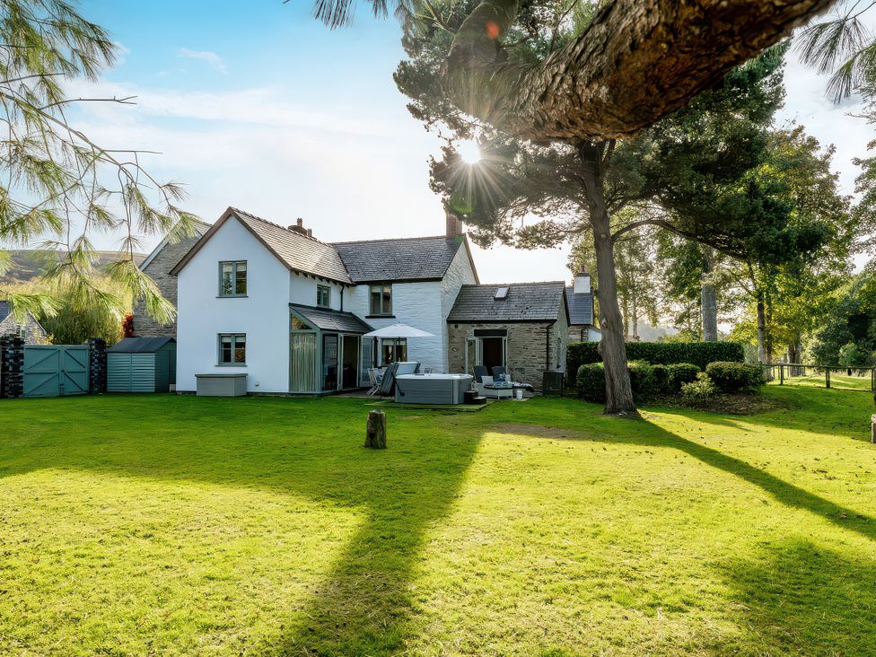 A house with a garden and trees at Cilan Farmhouse in Llandrillo