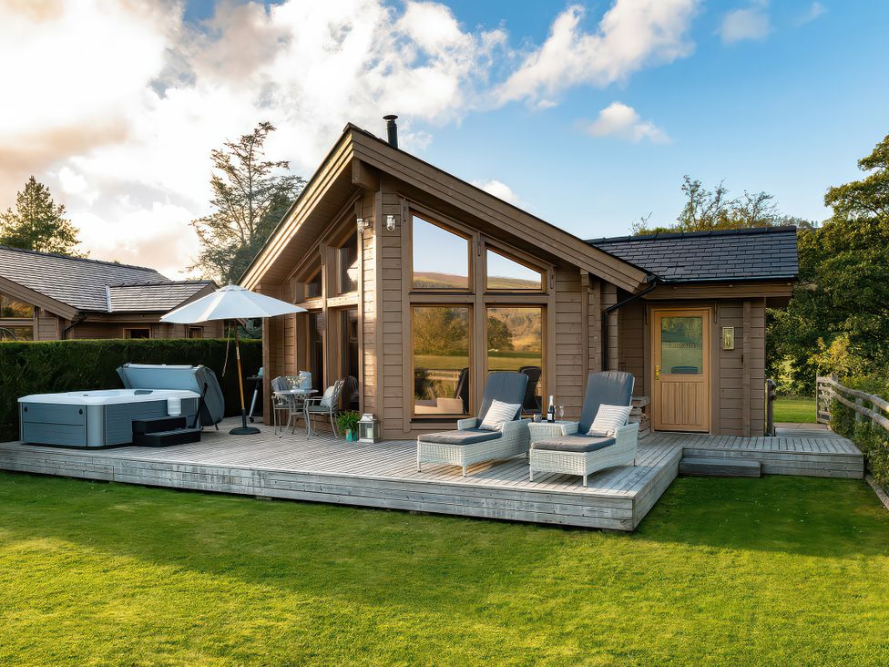 An outdoor area with a log cabin and furniture at Lagom Log Cabin in Llandrillo