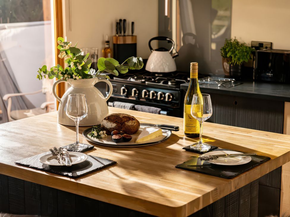 A kitchen with a table set for dining at Lagom Log Cabin in Llandrillo
