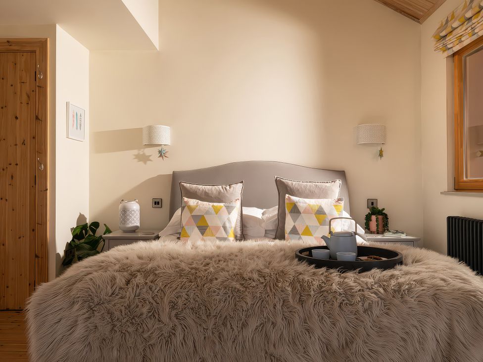 A bedroom with a bed and pillows at Lagom Log Cabin in Llandrillo