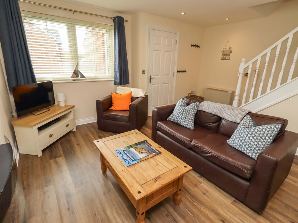 A living room with a television, sofa, and coffee table at 35 Longbeach Drive