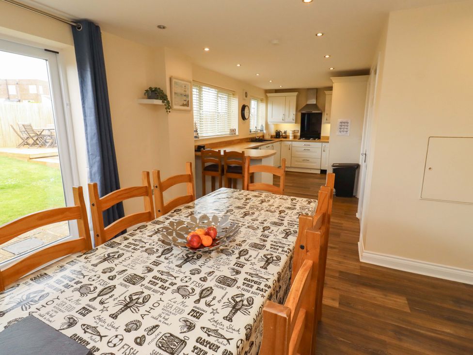 A dining room with a table and apples in a bowl at 35 Longbeach Drive 