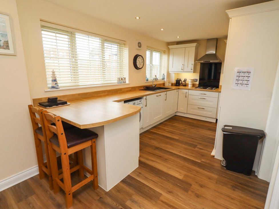 A kitchen with a counter and bar stools at 35 Longbeach Drive