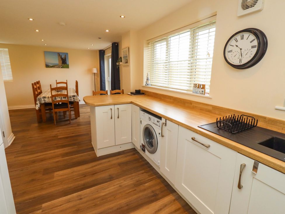 A kitchen with a washing machine and sink at 35 Longbeach Drive