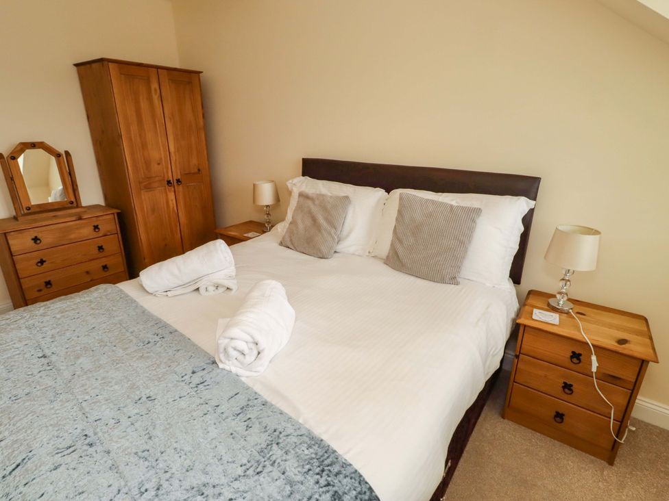 A bedroom with a bed and wooden furniture at 35 Longbeach Drive