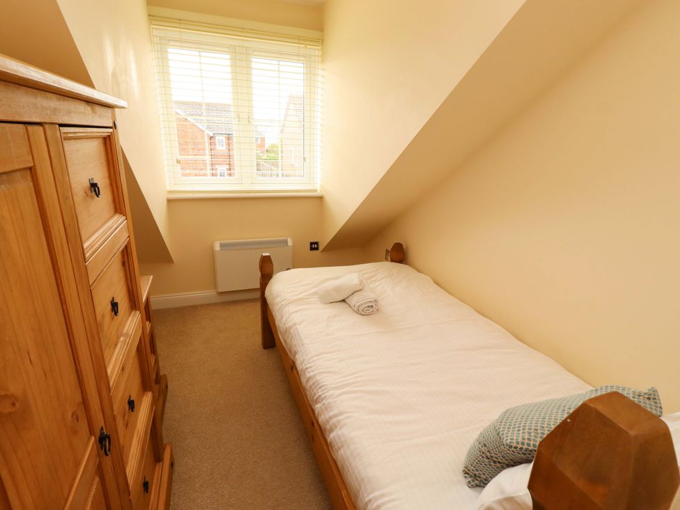 A bedroom with a single bed and wardrobe at 35 Longbeach Drive