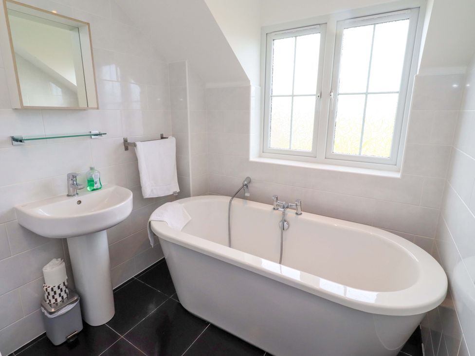 A bathroom with a bathtub and washbasin at 35 Longbeach Drive