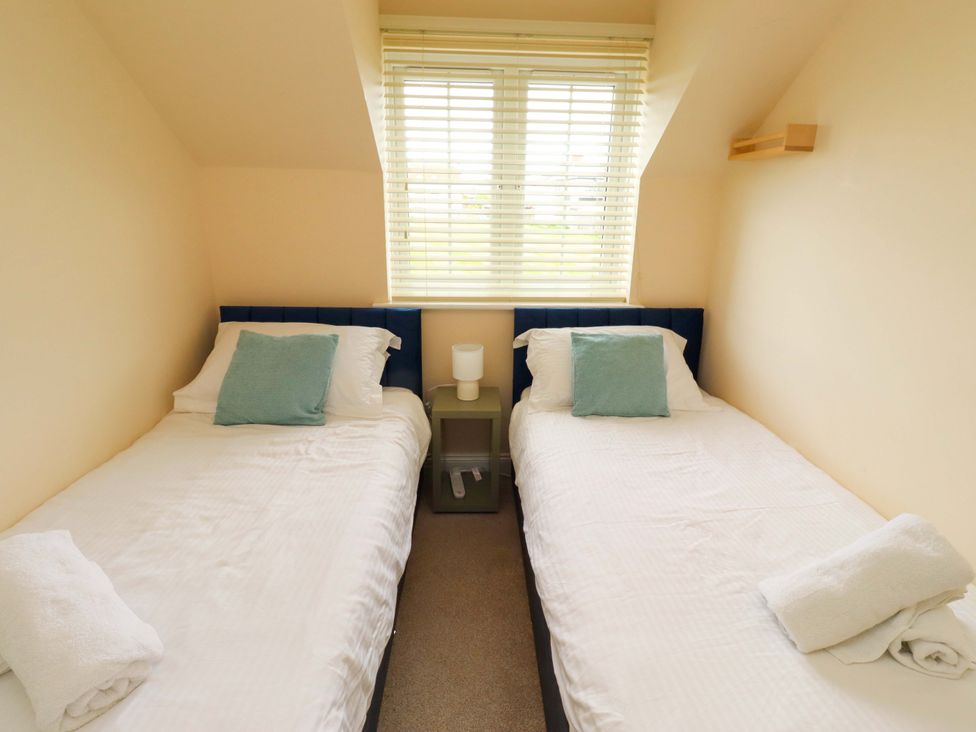 A bedroom with two single beds and a window at 35 Longbeach Drive