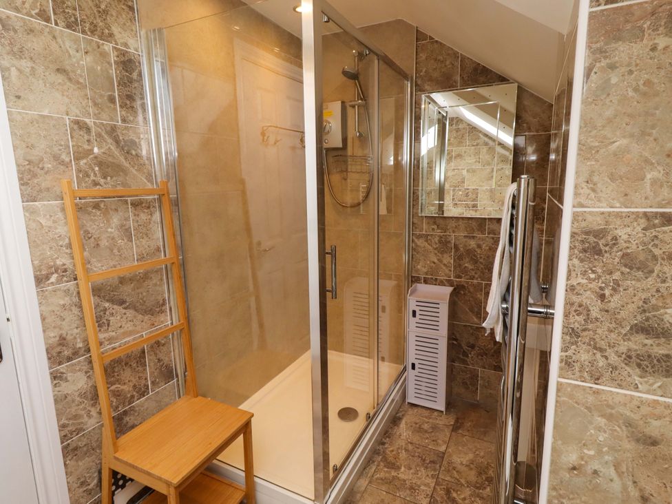 A bathroom with a shower, mirror, ladder and towel rail at 35 Longbeach Drive