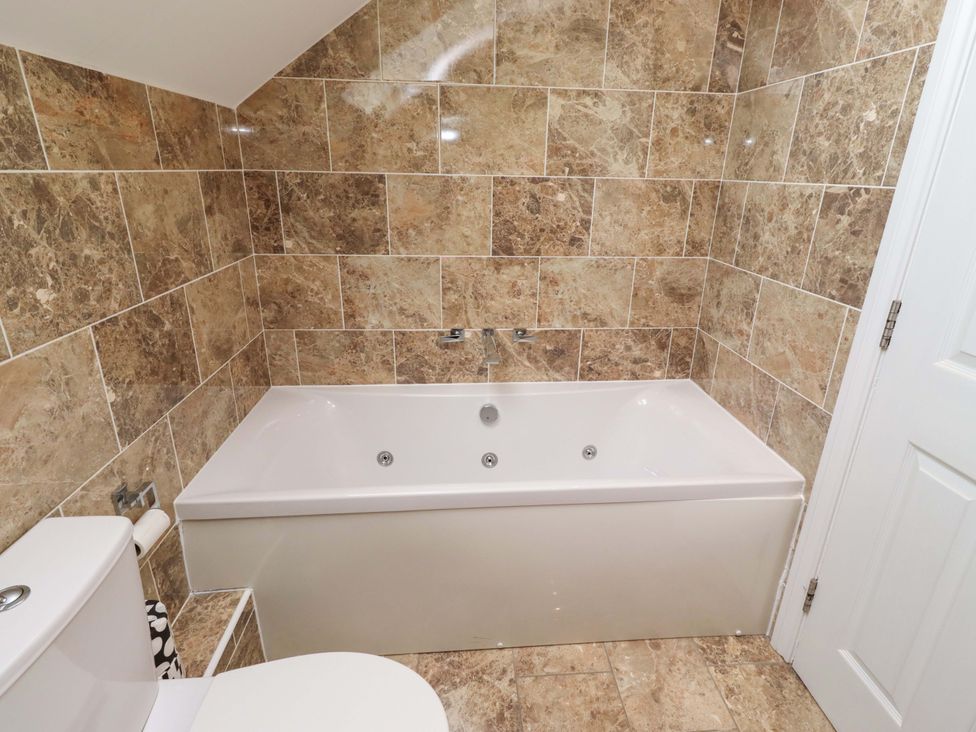 A bathroom with a bathtub and toilet at 35 Longbeach Drive
