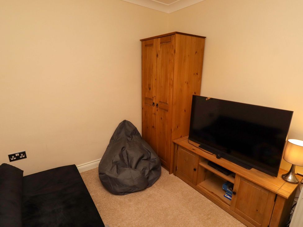 A living room with furniture including a television and a wardrobe at 35 Longbeach Drive