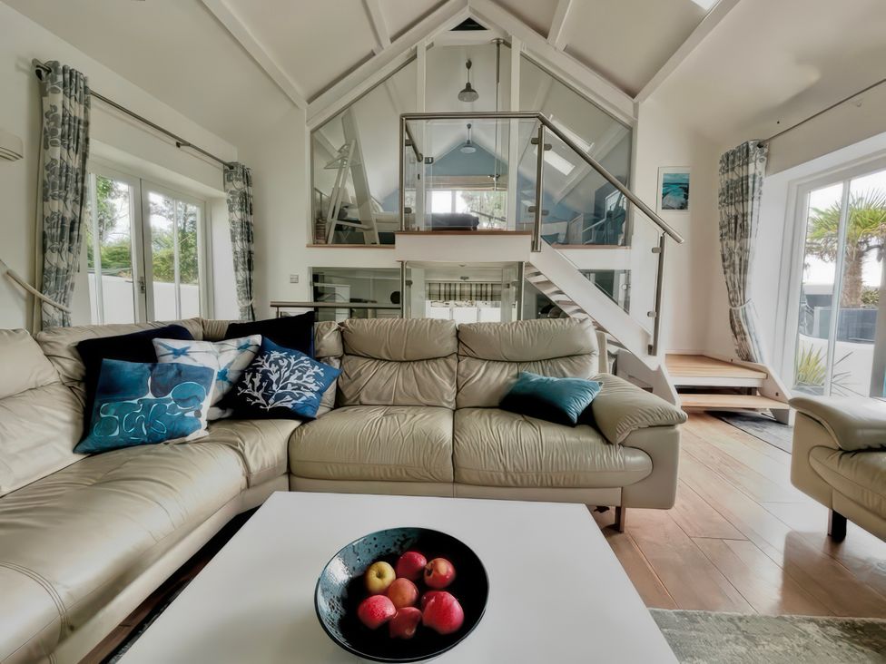 A living room with a sofa and coffee table at The Cowshed in Portscatho