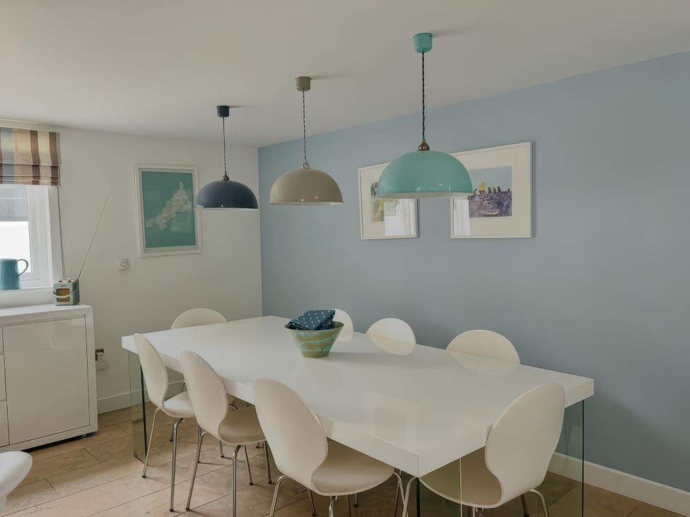 A dining room with a table and chairs at The Cowshed in Portscatho