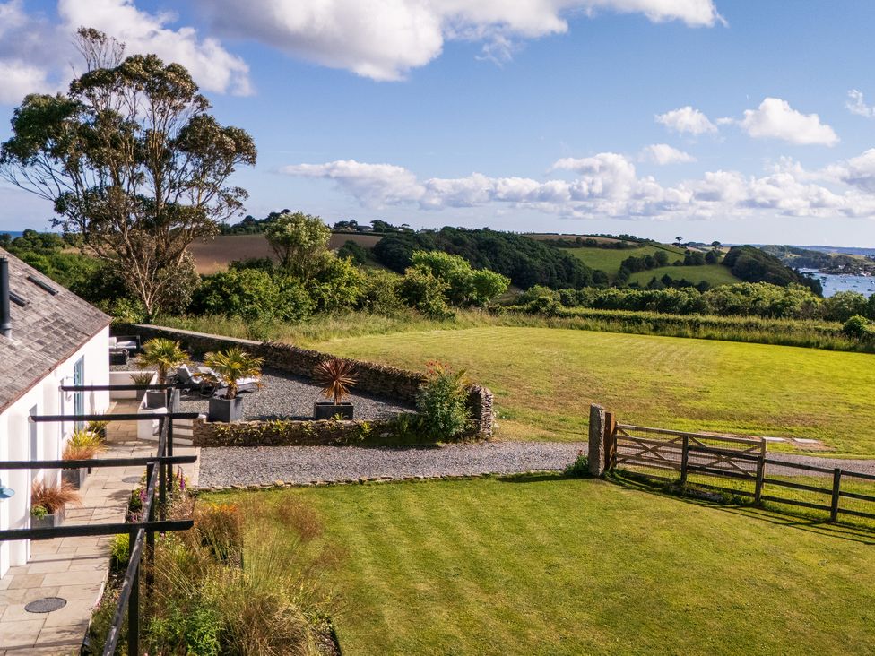 An outdoor view with grass and a stone wall at The Cowshed in Portscatho