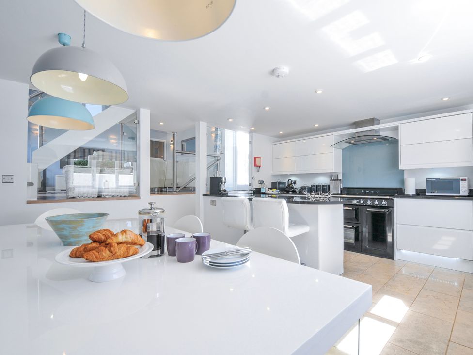 A kitchen with a stove, oven, and dining table at The Cowshed in Portscatho