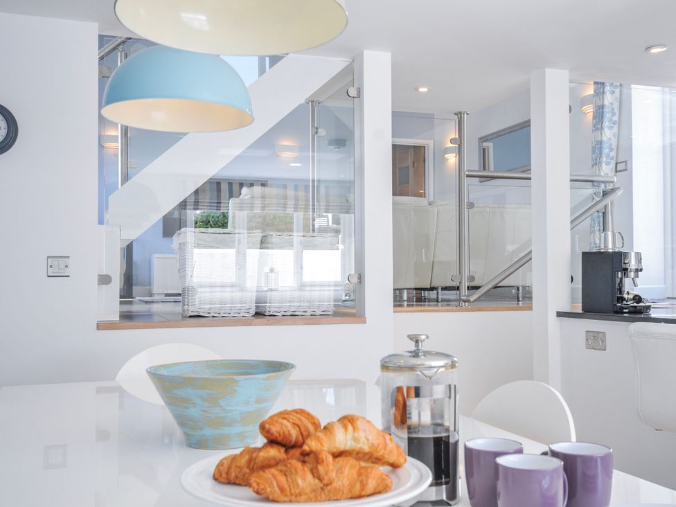 A kitchen with croissants and coffee on the table at The Cowshed in Portscatho