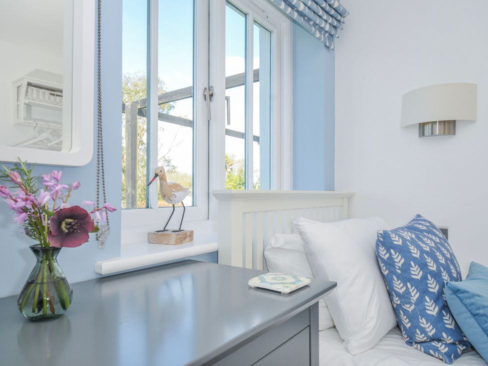 A bedroom with a bed and window at The Cowshed in Portscatho