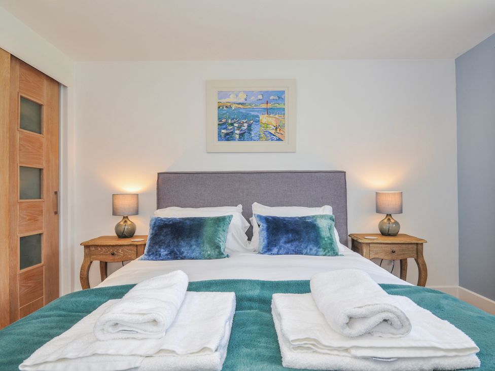 A bedroom featuring a bed with pillows and bedside tables at The Cowshed in Portscatho