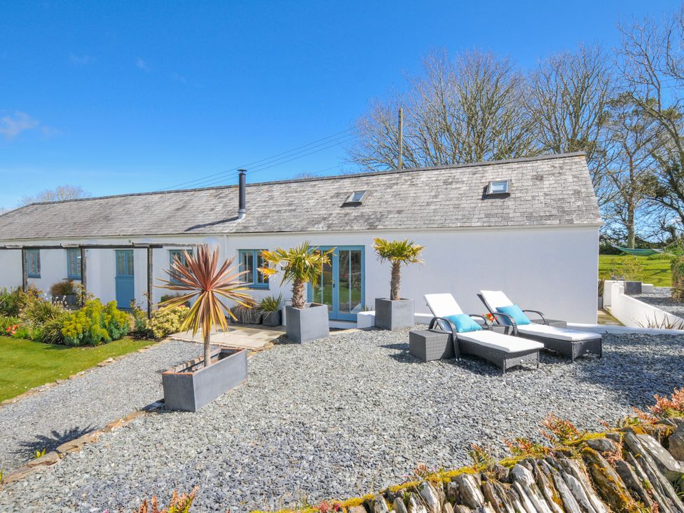 An outdoor area with deck chairs and planters at The Cowshed in Portscatho