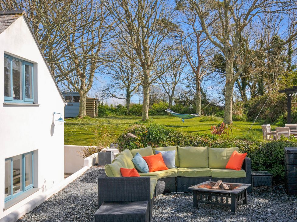 A garden with a sofa and coffee table at The Cowshed in Portscatho