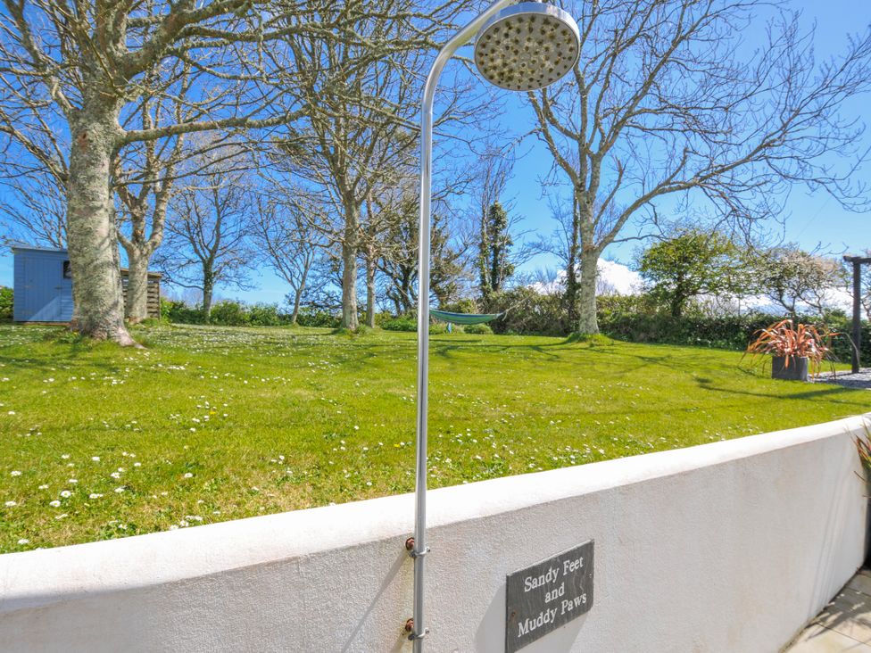 An outdoor shower and grassy area at The Cowshed in Portscatho